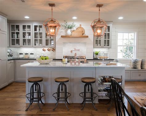 Farm kitchen - Farmhouse Kitchen. Example of a farmhouse l-shaped medium tone wood floor and brown floor eat-in kitchen design in New York with a farmhouse sink, recessed-panel cabinets, beige cabinets, gray backsplash, subway tile backsplash, stainless steel appliances, an island and white countertops. Save Photo. 